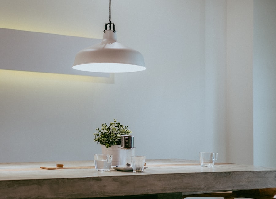 A white pendant light glowing over a dining table